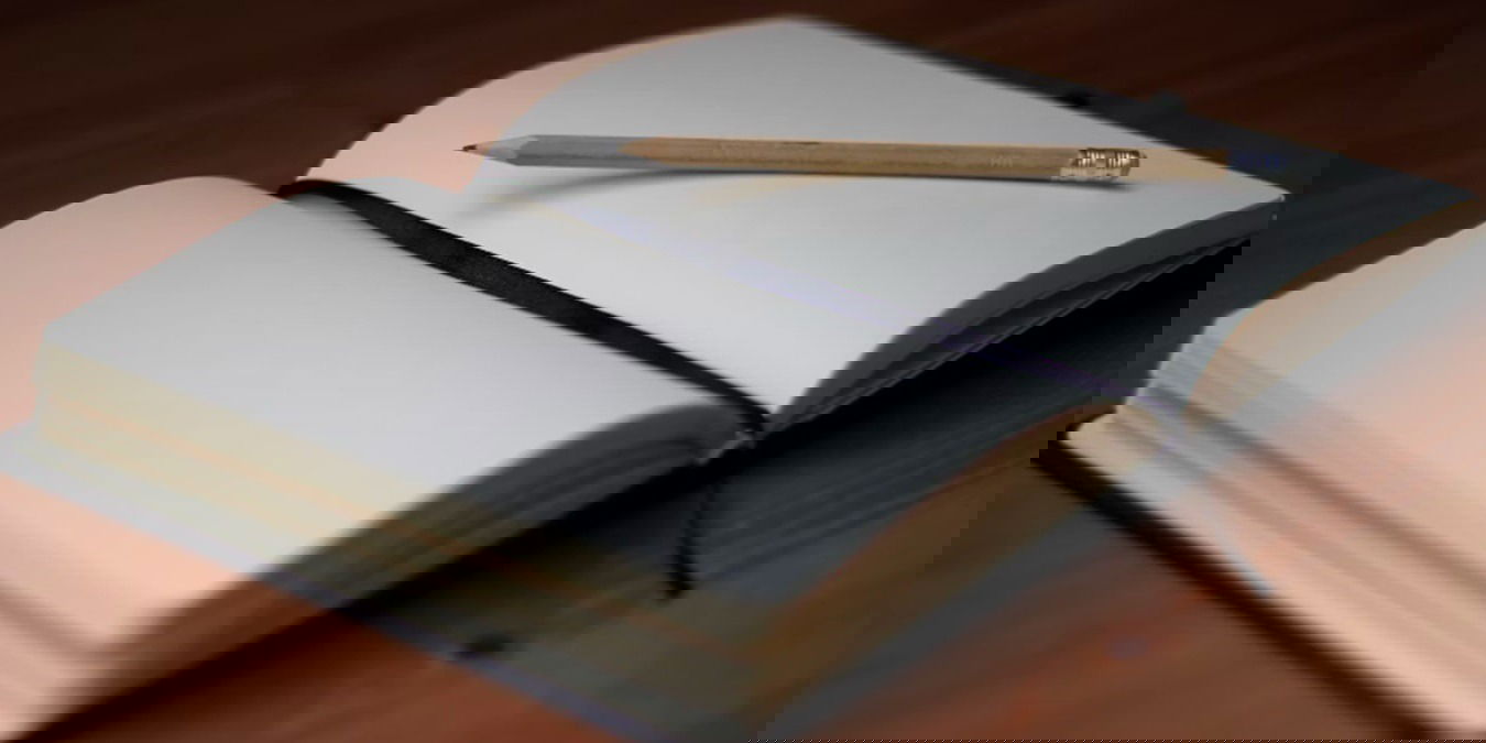 An open journal with a pencil