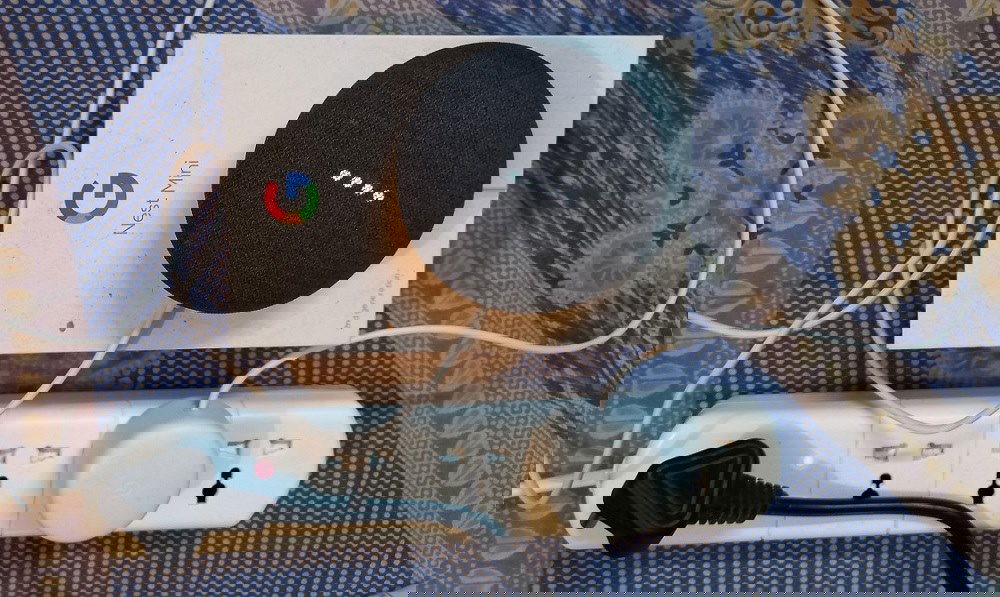 Nest Mini 2nd generation speaker with its white lights on and in listening mode.