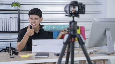 Man recording a video of a product and recommending it