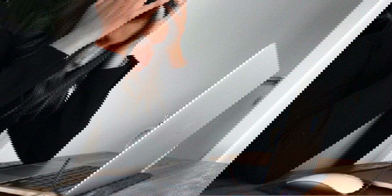 woman in black shirt frustrated at her laptop computer