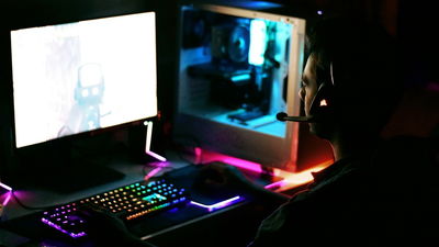 Person wearing headphones playing on a gaming pc