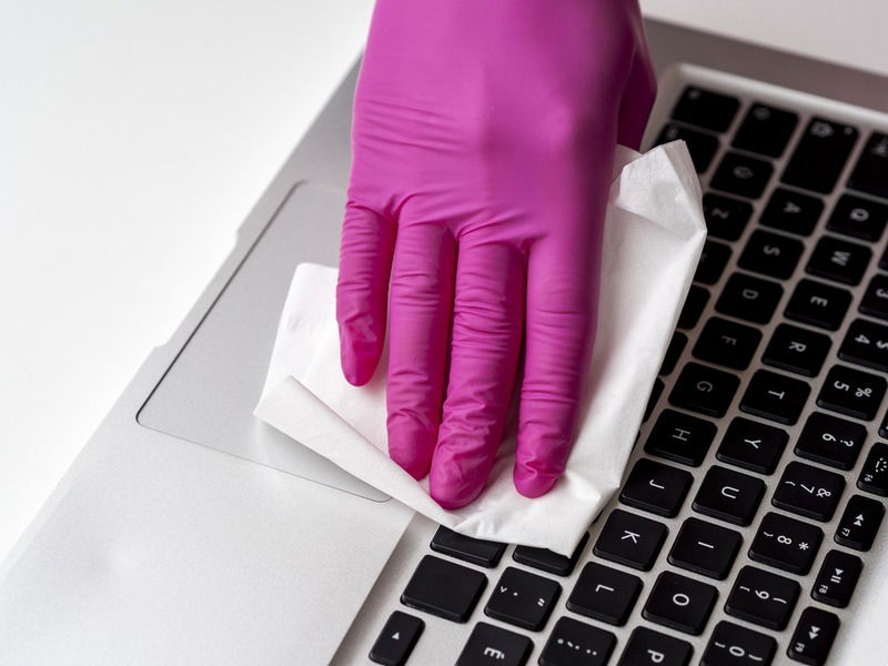 Laptop being cleaned with white cloth