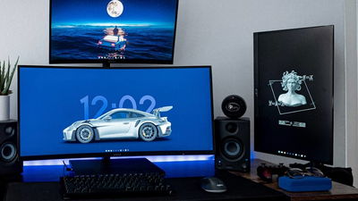 Three monitors setup on a desktop with keyboard.