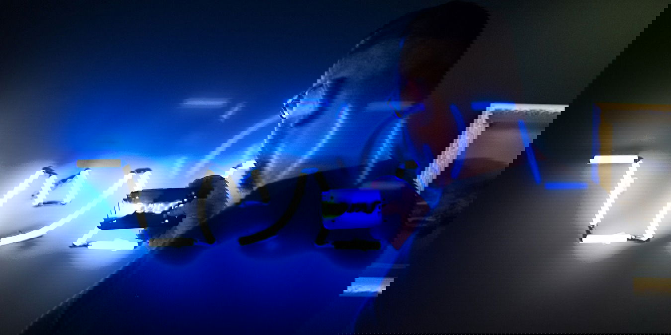 Man taking a photo of a neon sign