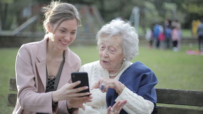 Young Lady And Female Older Adult Using An Iphone